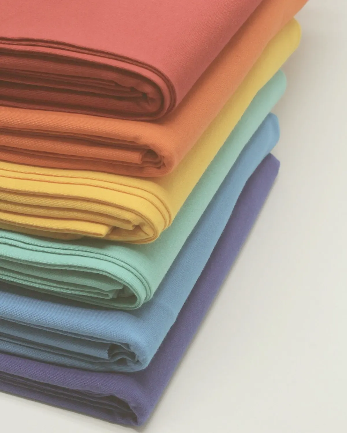 Folded lengths of dyed fabric in a range of colours